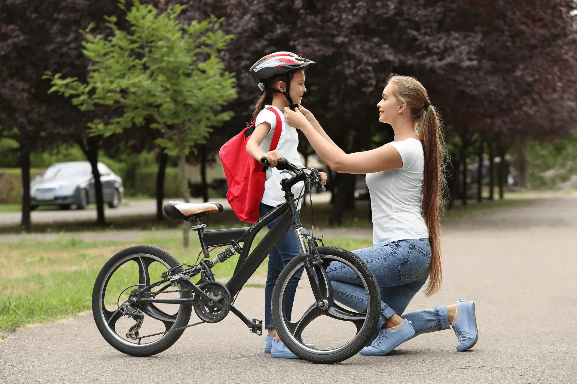 Mother helping child learn to ride a bike